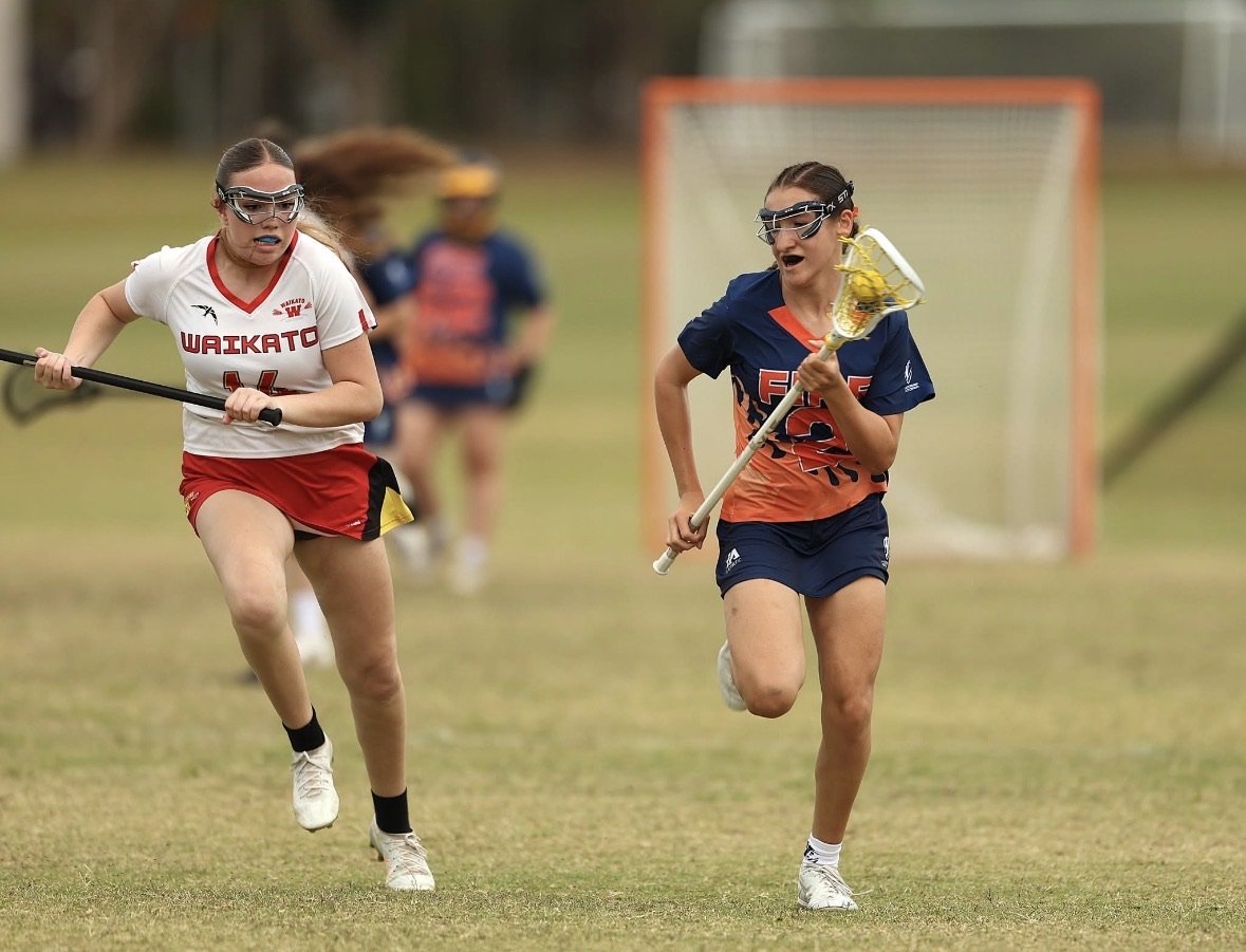 A FIRE player running with the ball as an opponent chases.