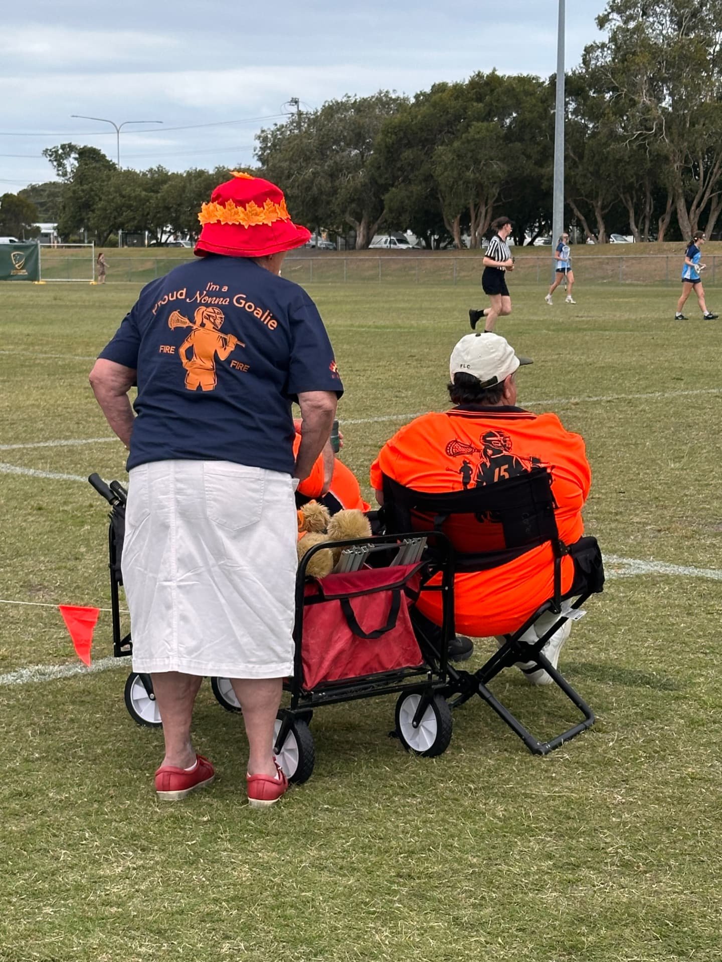 Supporters watching from the sideline with a wagon and folding chair.