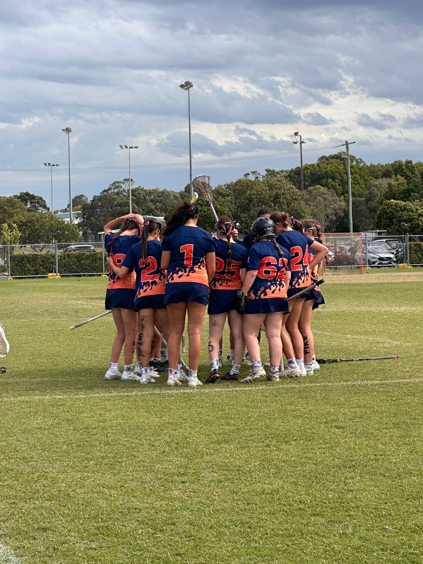 FIRE players in a team huddle on the field.