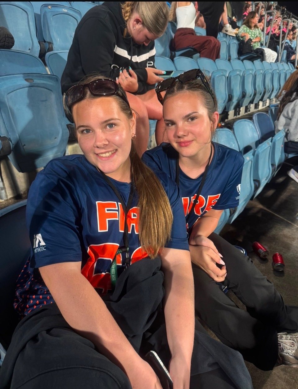 Ivy and a FIRE teammate sitting together in the stands.