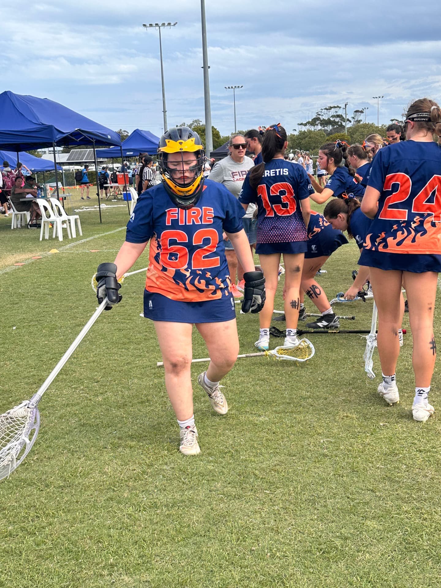 Ivy walking off the field in her FIRE #62 goalie gear with teammates nearby.