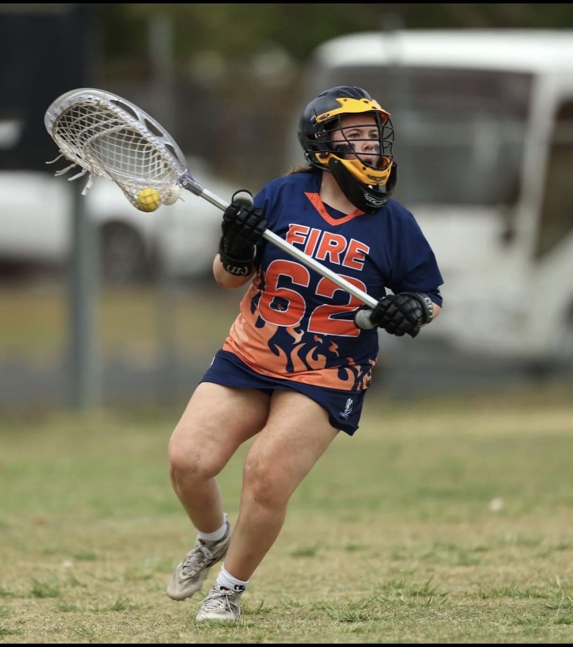 Ivy, in goal for FIRE wearing #62, clearing the ball with her goalie stick.