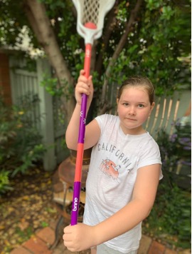 Ivy Merritt with a lacrosse stick at the beginning of her lacrosse journey in 2021.