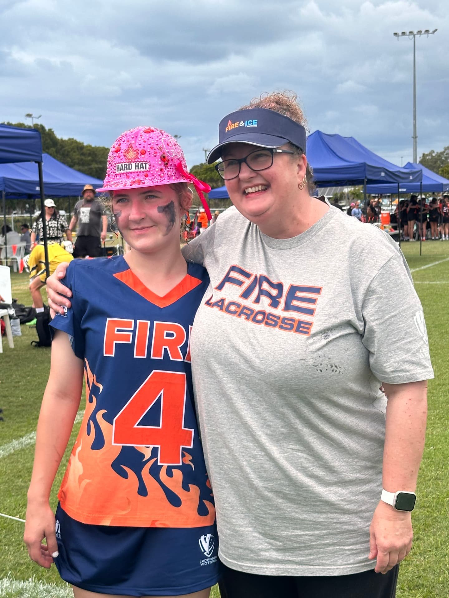 A FIRE player with a supporter wearing a FIRE Lacrosse t-shirt.